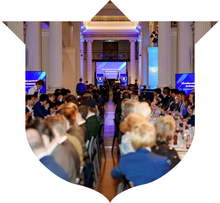 MULC Annual Dinner event with guests seated at long tables facing a stage.